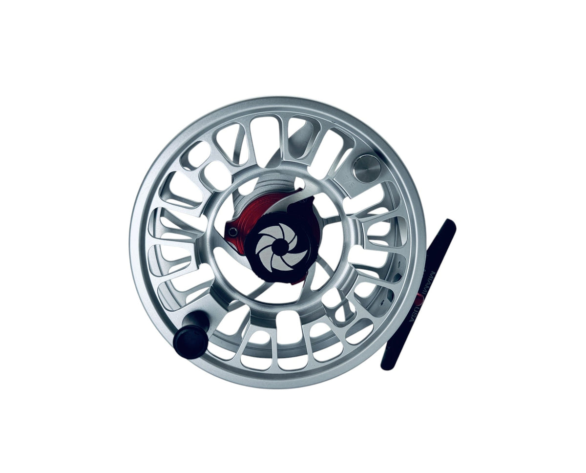 Silver GTR Reel flugfiskerulle med öppen design, svart handtag och röd-svarta detaljer, fotograferad ovanifrån.