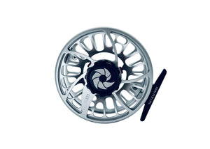 Silverfärgad GTS flugfiskerulle, svart mittnav, stora utskärningar, lätt spole, kolfiberbroms. Handtag märkt NAUTILUS.