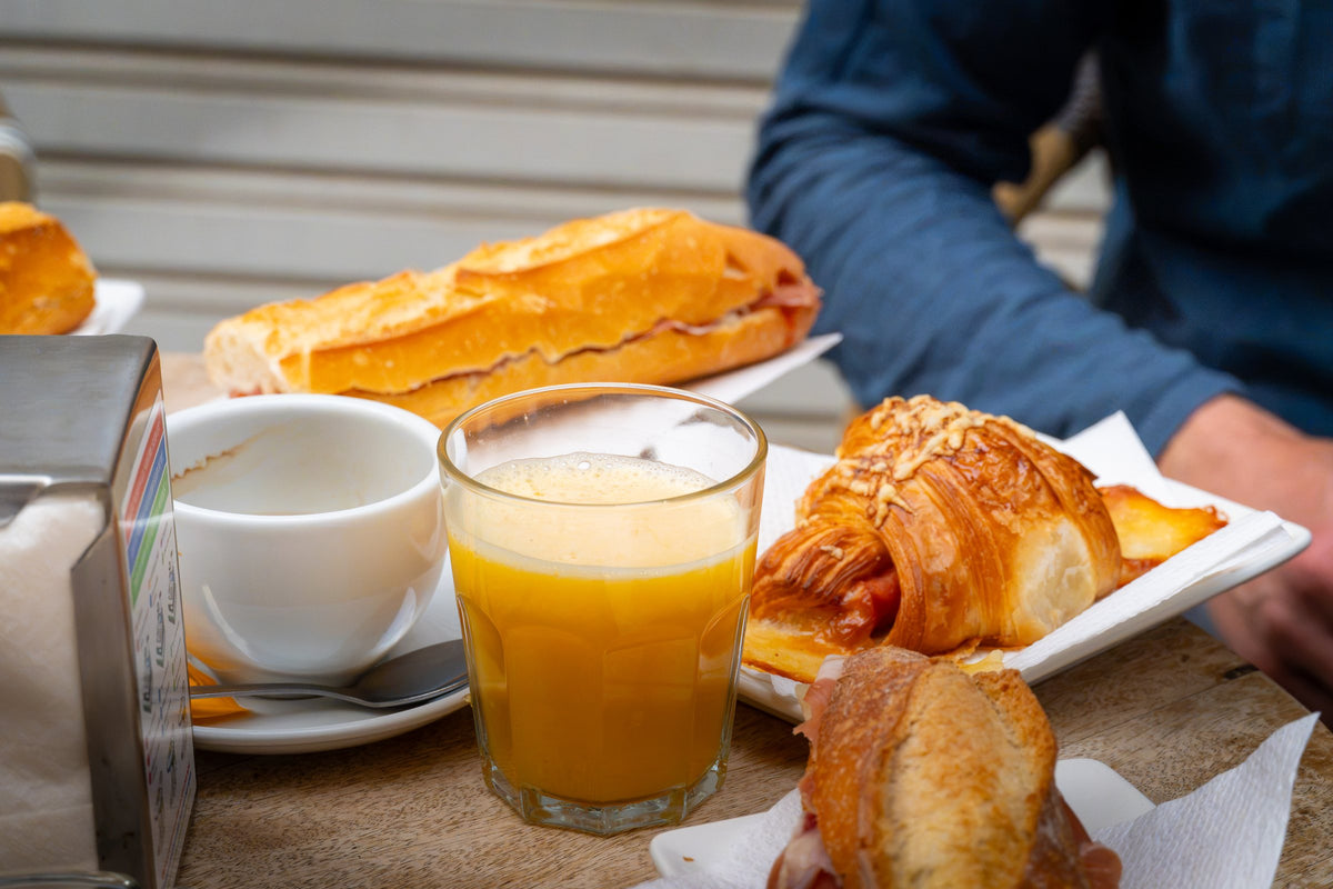 Färskpressad apelsinjuice, kaffe och smörgås med skinka – frukost under fiskeresan i Spanien