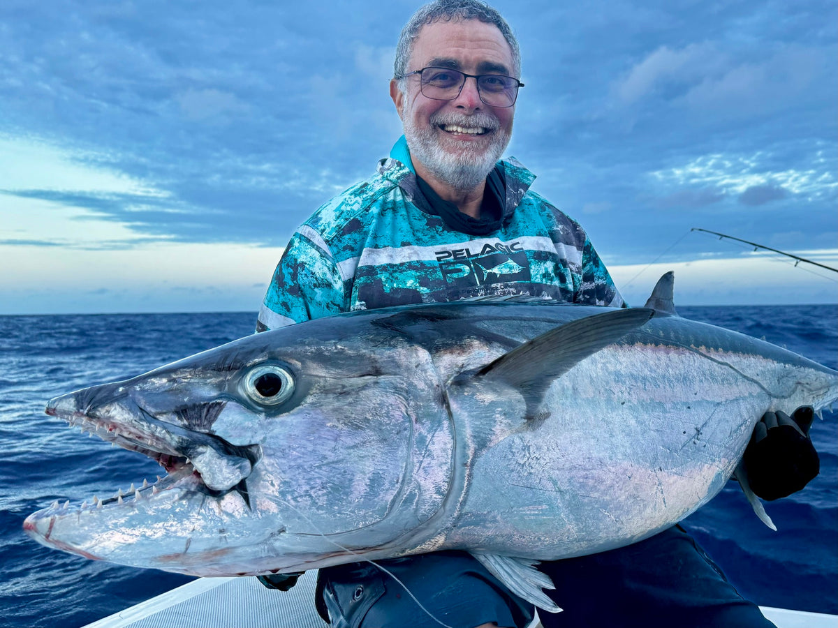 Fiskare håller upp dogtooth tuna ombord på liveaboard vid Rodrigues
